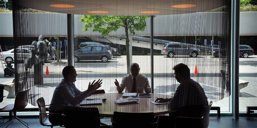 Managers vergaderen aan een ronde tafel..